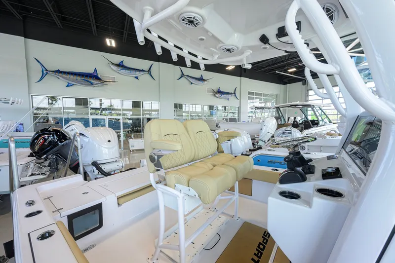 Slide: The Image of 2026 Sportsman Masters 247OE Bay Boat interior with beige seating in showroom. - 21