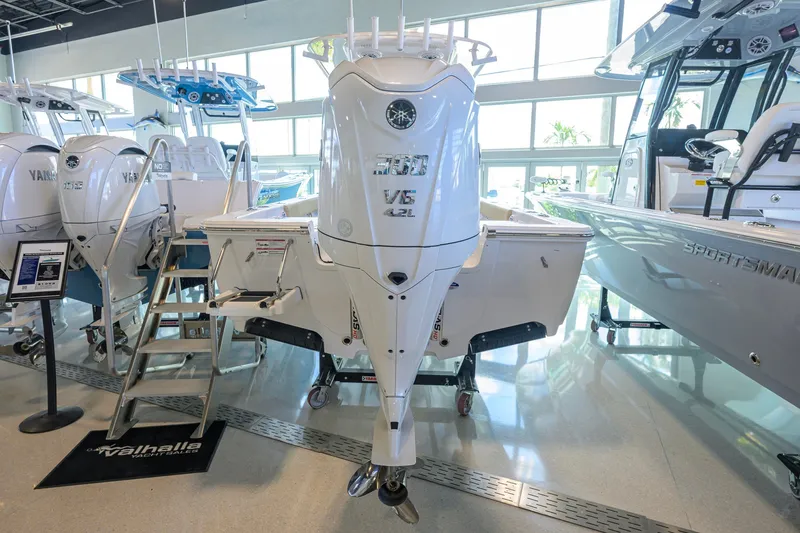 Slide: The Image of 2026 Sportsman Masters 247OE Bay Boat with Yamaha V6 engine in showroom. - 3