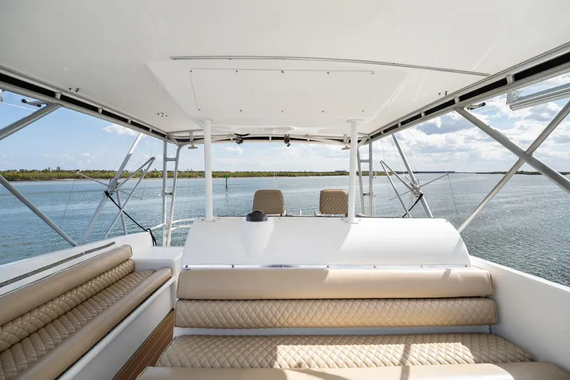 Slide: The Image of 1995 Hatteras 50 Convertible yacht interior with beige seating and scenic water view. - 13
