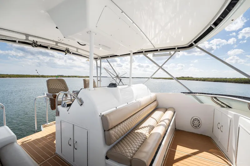 Slide: The Image of Luxurious 1995 Hatteras 50 Convertible yacht interior with seating, overlooking serene waters. - 15
