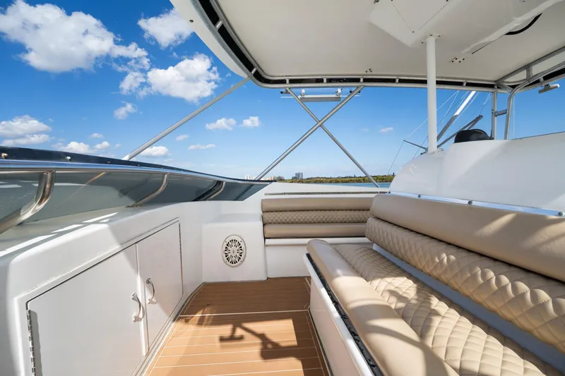 Slide: The Image of 1995 Hatteras 50 Convertible yacht interior with beige seating and clear blue sky. - 16