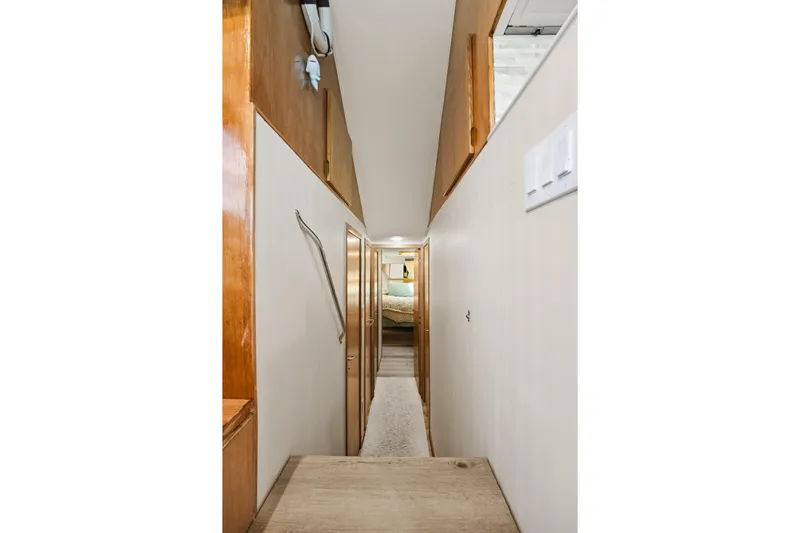 Slide: The Image of Narrow hallway inside 1995 Hatteras 50 Convertible yacht, featuring wooden accents and carpeted floor. - 27