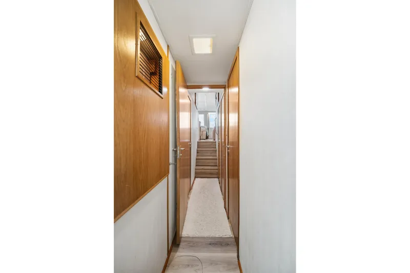 Slide: The Image of Hallway inside 1995 Hatteras 50 Convertible yacht, featuring wooden doors and carpeted floor. - 28