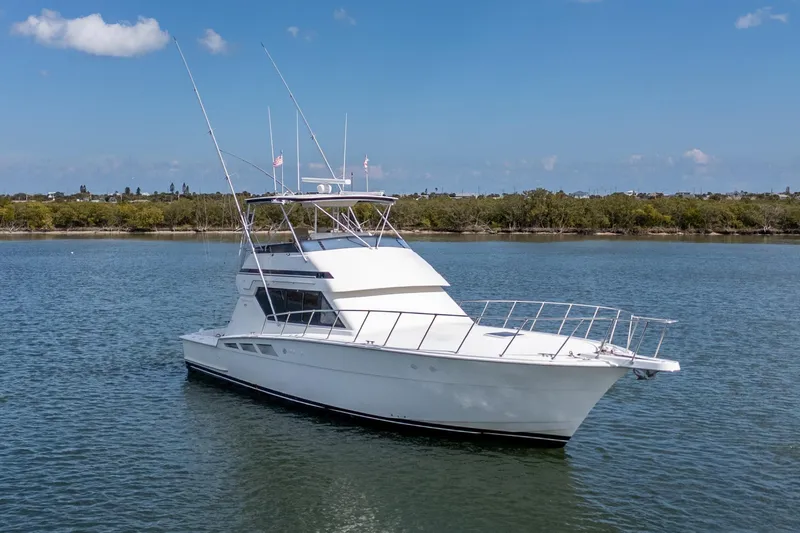 Slide: The Image of 1995 Hatteras 50 Convertible yacht on calm water under blue sky. - 3