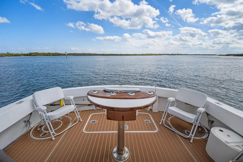 Slide: The Image of Aft deck of 1995 Hatteras 50 Convertible yacht with chairs and table, overlooking serene water. - 8