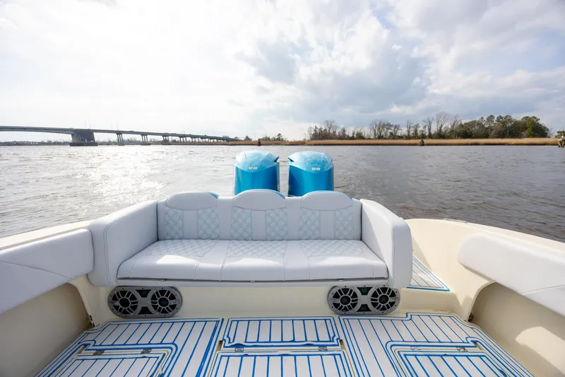Slide: The Image of 2014 Statement 350 Open boat interior with white seating and blue accents on the water. - 14