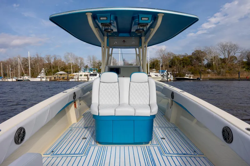 Slide: The Image of 2014 Statement 350 Open boat with blue and white seating, docked on a calm river. - 17