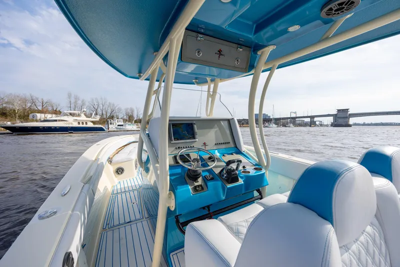 Slide: The Image of 2014 Statement 350 Open boat interior with blue accents, steering console, and waterfront view. - 18