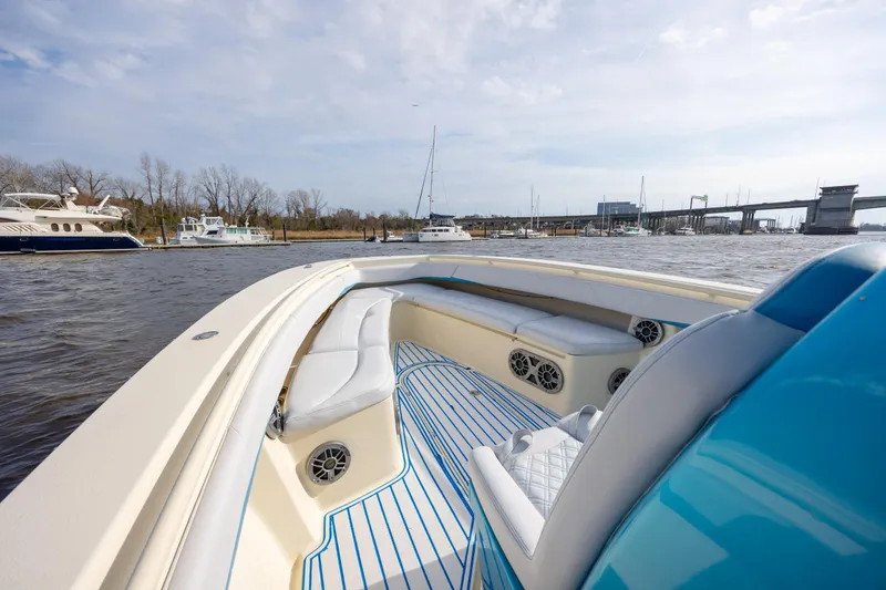 Slide: The Image of 2014 Statement 350 Open boat with white seating, blue accents, and scenic marina view. - 24