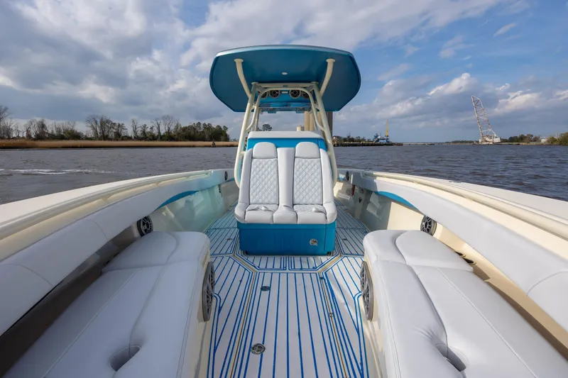 Slide: The Image of 2014 Statement 350 Open boat interior with white seating and blue accents on a river. - 27