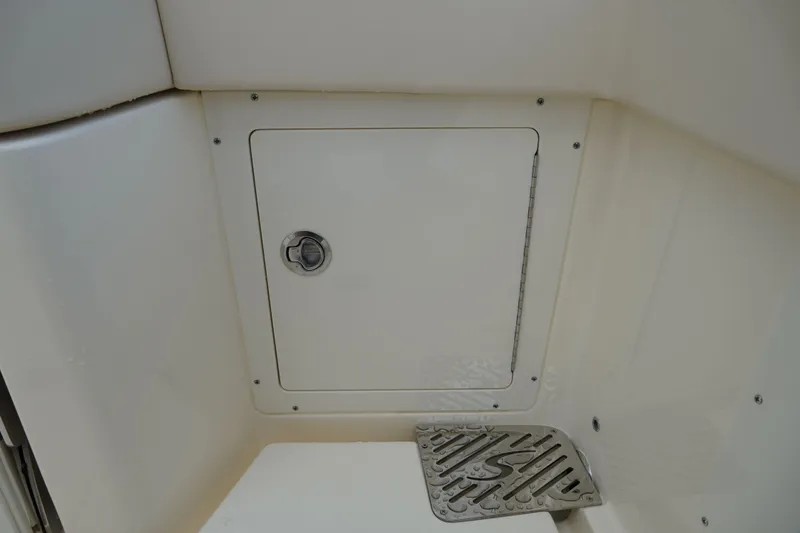 Slide: The Image of 2026 Scout 288 LXF boat storage compartment with secure latch and drainage area. - 15