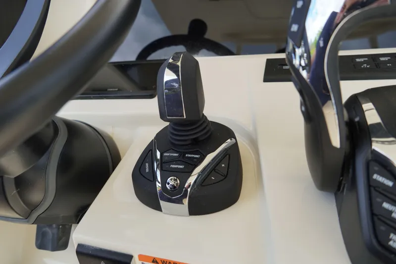 Slide: The Image of 2026 Scout 288 LXF boat control panel with joystick and steering wheel. - 24