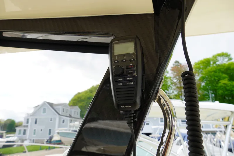 Slide: The Image of 2026 Scout 288 LXF boat with Garmin radio, docked near waterfront homes. - 28