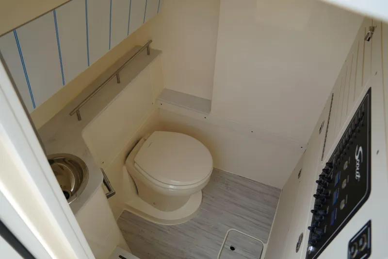 Slide: The Image of 2026 Scout 288 LXF boat interior bathroom with toilet and sink. - 31