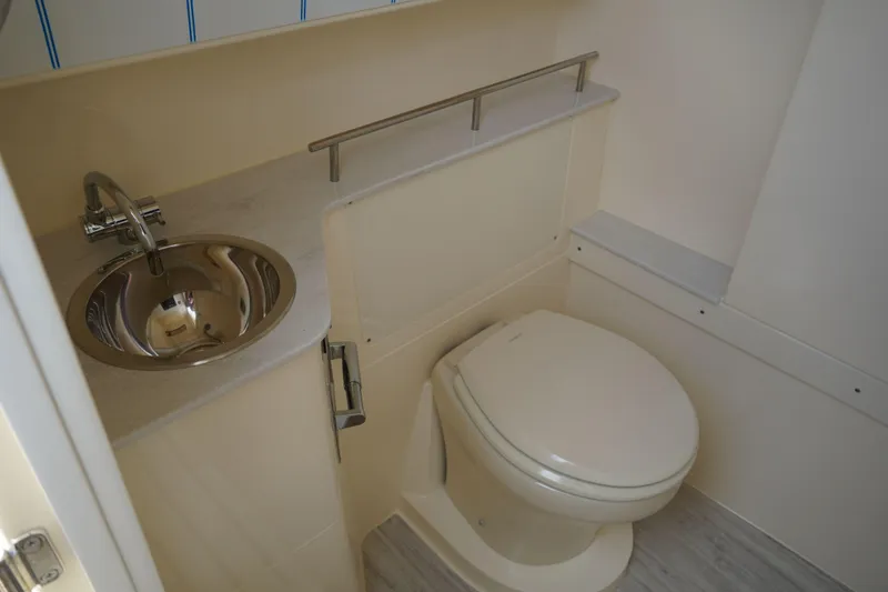 Slide: The Image of 2026 Scout 288 LXF boat bathroom with sink and toilet, featuring modern design. - 33