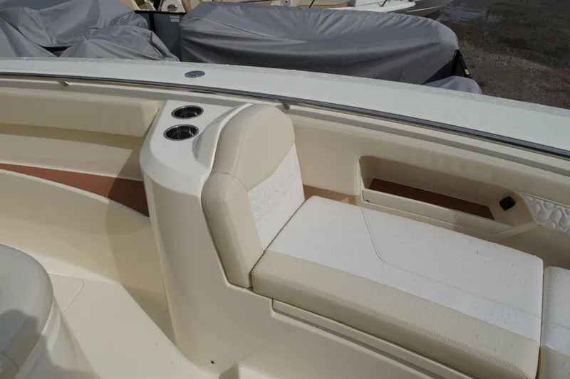 Slide: The Image of 2026 Scout 288 LXF boat interior with beige seating and cup holders. - 40