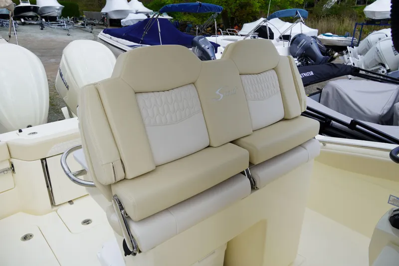 Slide: The Image of 2026 Scout 288 LXF boat with beige leather seats in a marina setting. - 51