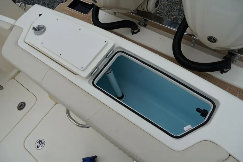 Slide: The Image of 2026 Scout 288 LXF boat interior with open storage compartment and visible engine components. - 59