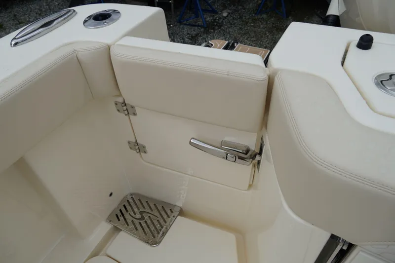 Slide: The Image of 2026 Scout 288 LXF boat interior with beige seating and stainless steel hardware. - 64