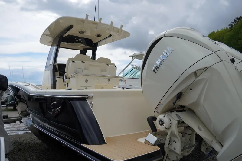 Slide: The Image of 2026 Scout 288 LXF boat with Yamaha engine, docked under cloudy skies. - 65