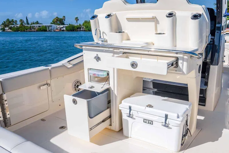Slide: The Image of Manufacturer Provided Image: 2026 Scout 288 LXF boat interior with storage, sink, and Yeti cooler on deck. - 9