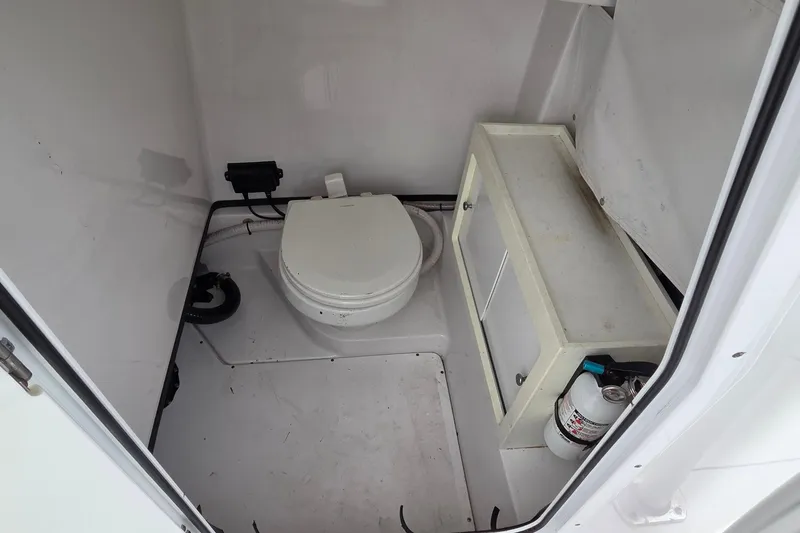 Slide: The Image of 2020 Sportsman Open 282 Center Console boat interior with toilet and storage cabinet. - 17