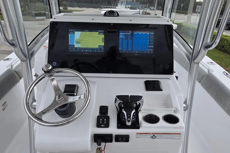 Slide: The Image of 2020 Sportsman Open 282 Center Console boat dashboard with dual screens and steering wheel. - 8