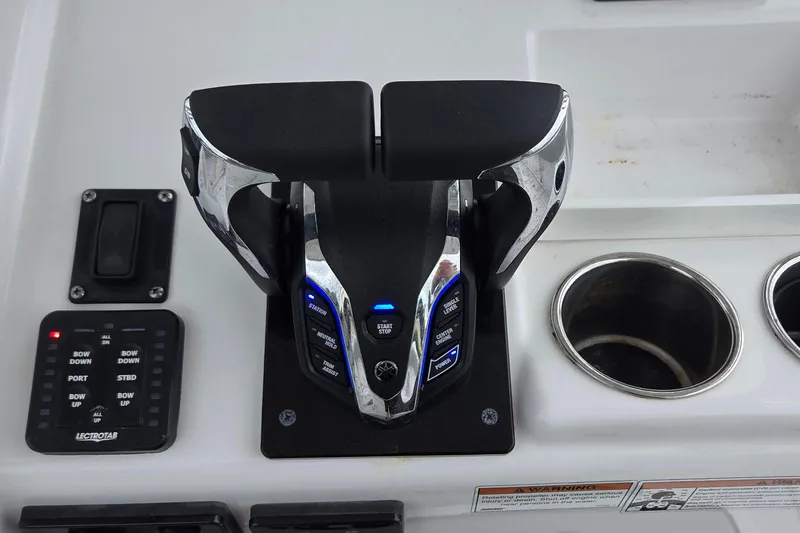 Slide: The Image of Control panel of 2020 Sportsman Open 282 Center Console boat with throttle and cup holders. - 9