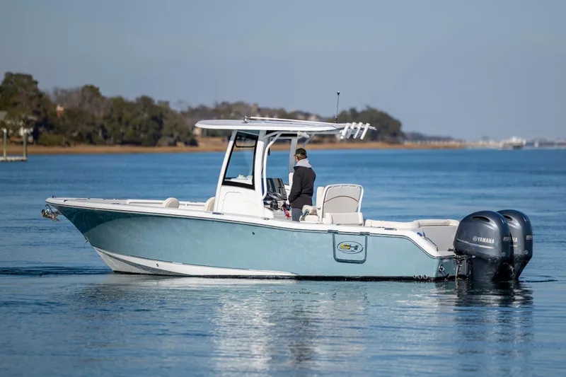 The Image of 2022 Sea Hunt Ultra 265 SE boat on calm water with dual Yamaha engines. - 0
