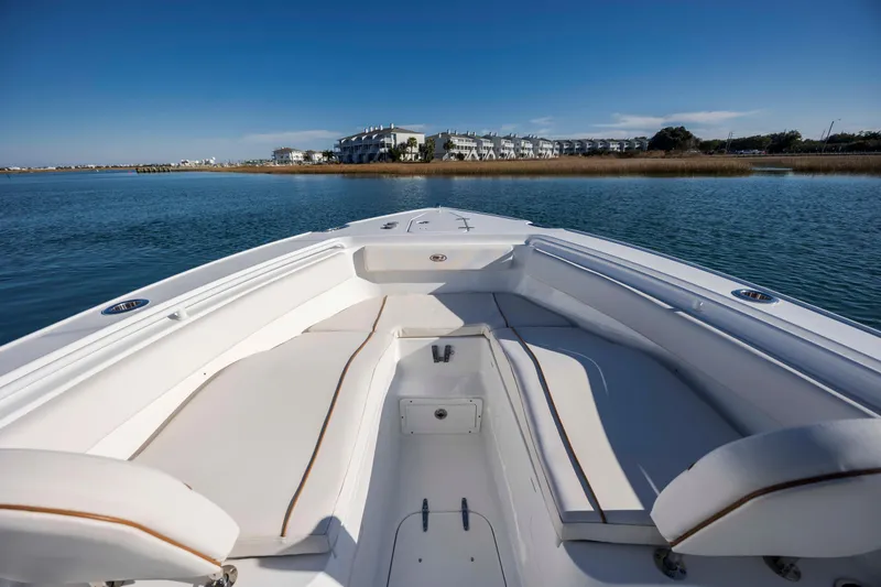 Slide: The Image of 2022 Sea Hunt Ultra 265 SE boat on calm water with scenic coastal view. - 10