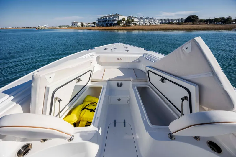 Slide: The Image of 2022 Sea Hunt Ultra 265 SE boat with open storage compartments on calm water. - 11