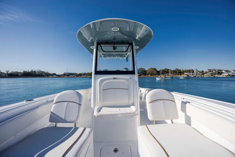 Slide: The Image of 2022 Sea Hunt Ultra 265 SE boat interior with seating, on calm water. - 14