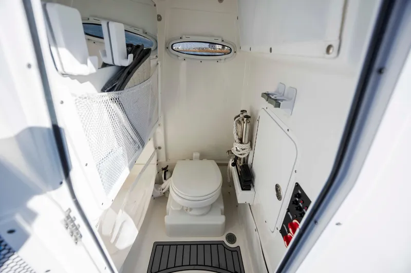 Slide: The Image of 2022 Sea Hunt Ultra 265 SE boat interior bathroom with toilet and storage. - 15