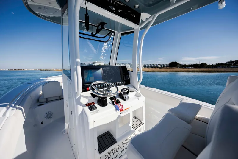 Slide: The Image of 2022 Sea Hunt Ultra 265 SE boat interior with modern helm and scenic water view. - 17
