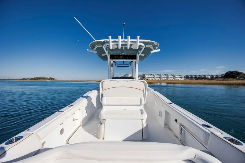 Slide: The Image of 2022 Sea Hunt Ultra 265 SE boat on calm water with clear blue sky. - 23