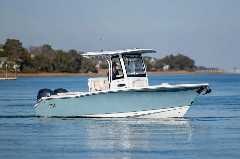 Slide: The Image of 2022 Sea Hunt Ultra 265 SE boat on calm water, showcasing sleek design and dual engines. - 4
