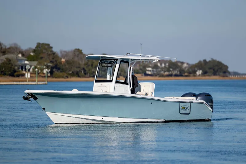 Slide: The Image of 2022 Sea Hunt Ultra 265 SE boat on calm water, showcasing sleek design and dual engines. - 6