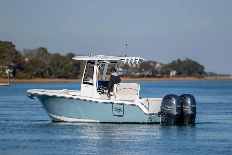 Slide: The Image of 2022 Sea Hunt Ultra 265 SE boat on calm water with dual Yamaha engines. - 8