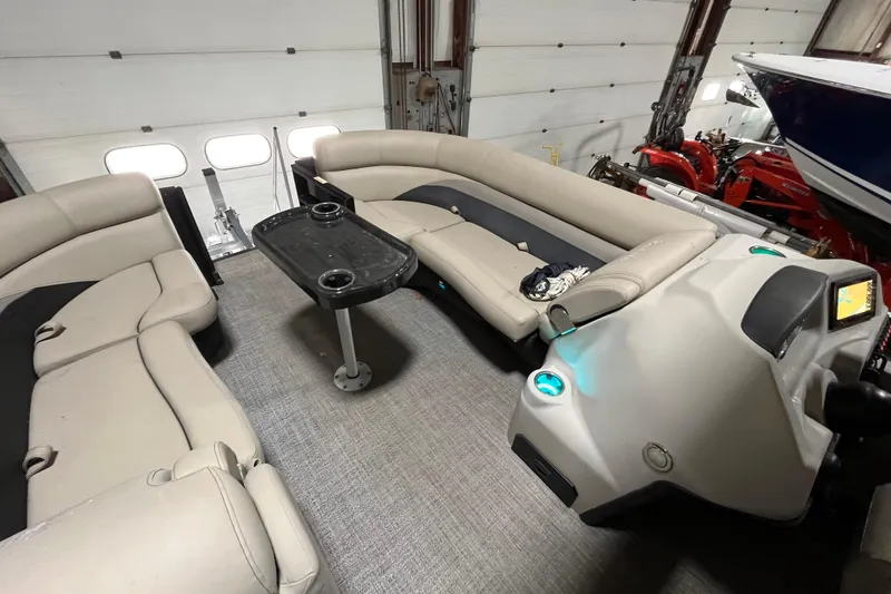 Slide: The Image of 2021 Barletta Cabrio 20UC pontoon boat interior with beige seating and central table. - 14