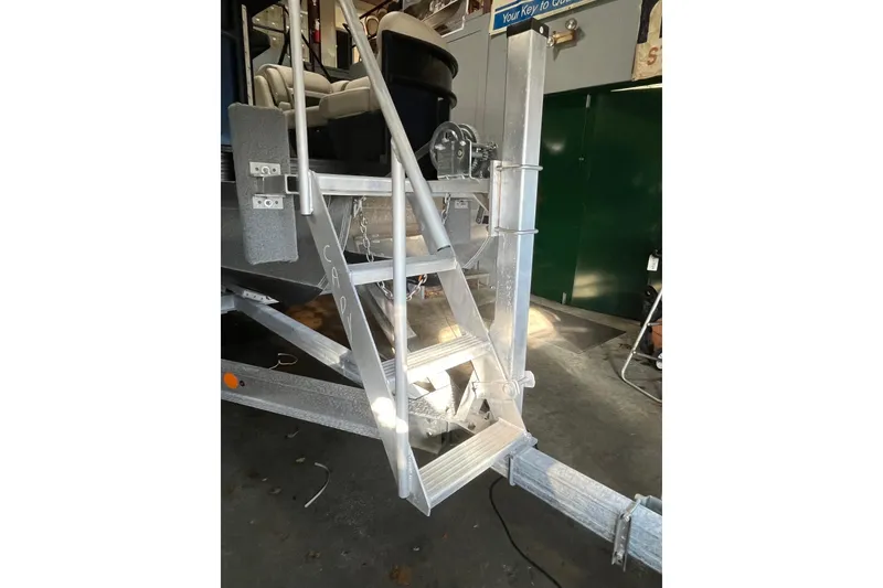 Slide: The Image of 2021 Barletta Cabrio 20UC boat trailer with metal steps in a garage setting. - 18