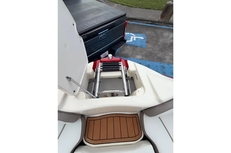Slide: The Image of 2014 Yamaha Boats 242 Limited with open hatch and ladder, parked near a Ford truck. - 21