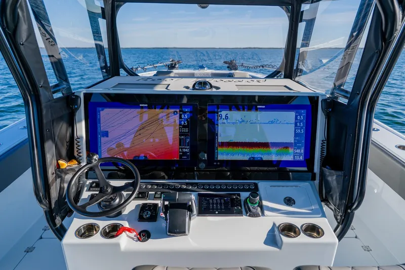 Slide: The Image of Freeman 42LR 2025 boat dashboard with navigation screens and steering wheel on open water. - 31