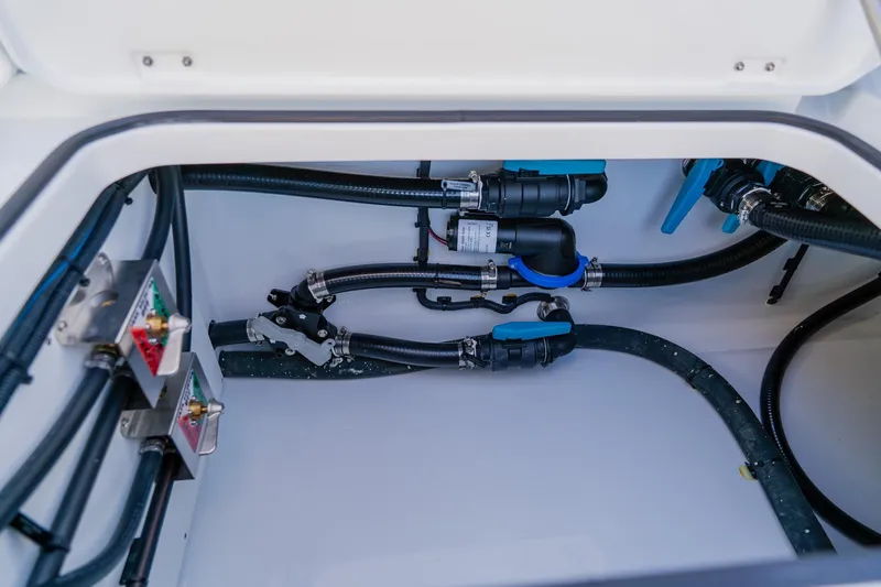 Slide: The Image of Freeman 42LR 2025 boat plumbing system with hoses and valves in storage compartment. - 38