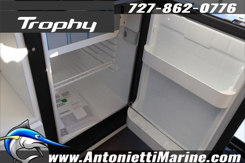 Slide: The Image of Open refrigerator inside 2026 Bayliner Trophy T29 Explorer boat, featuring storage compartments. - 26