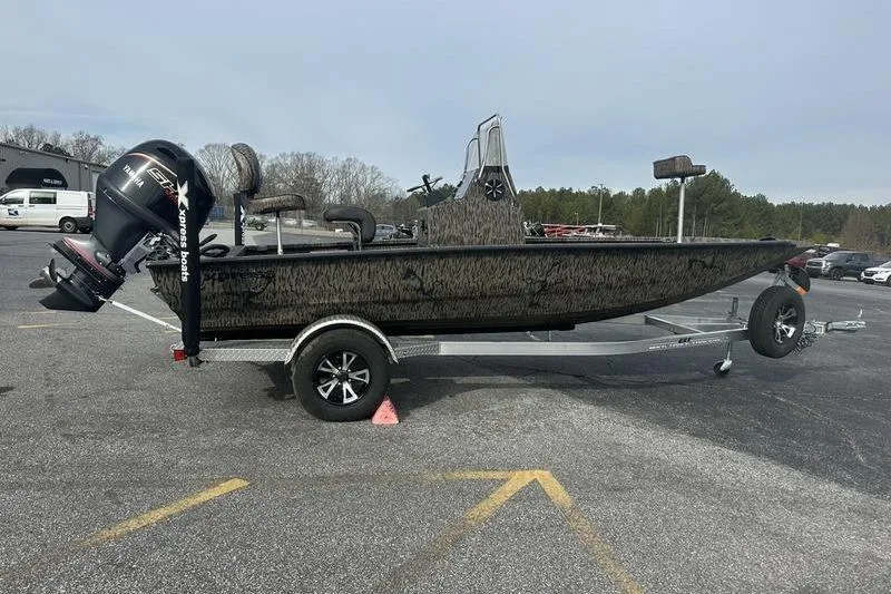 Slide: The Image of 2026 Xpress H190B Bay boat on trailer, parked in a lot, side view. - 2