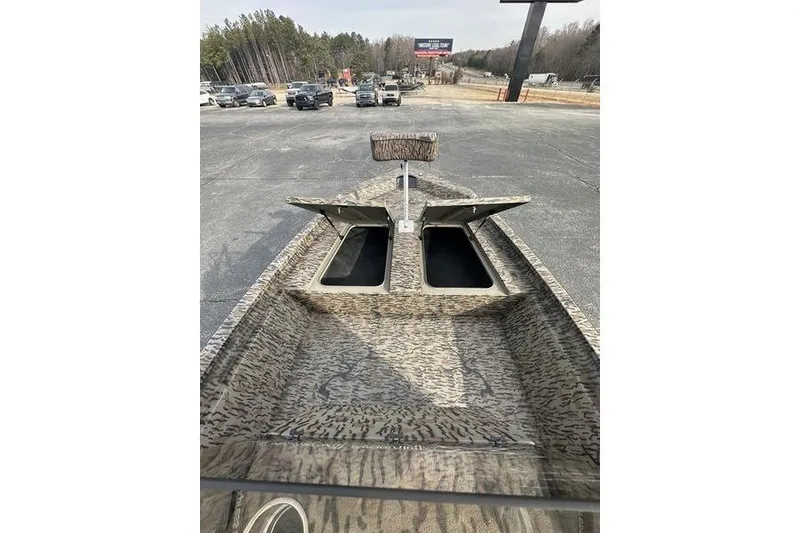 Slide: The Image of 2026 Xpress H190B Bay boat with open storage compartments, parked outdoors. - 4