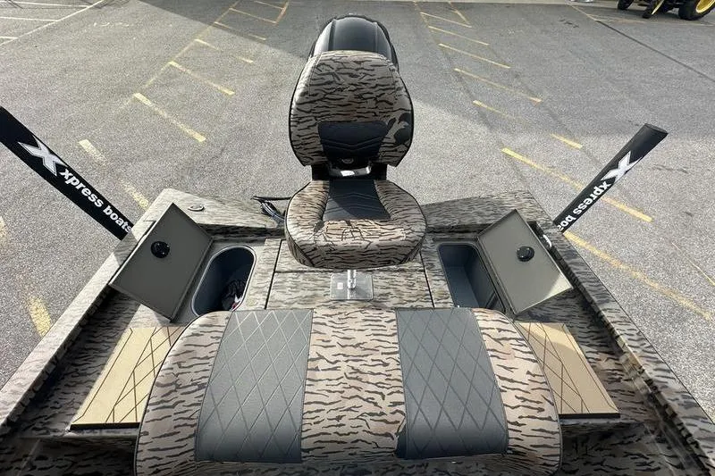 Slide: The Image of 2026 Xpress H190B Bay boat interior with camo seats and storage compartments. - 7