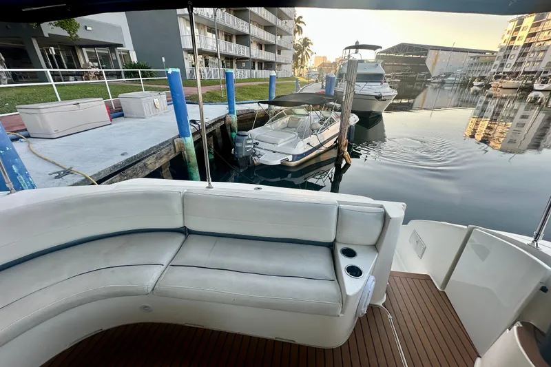 Slide: The Image of 2005 Cruisers Yachts 500 Express docked, featuring spacious seating and scenic marina view. - 22