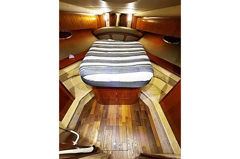 Slide: The Image of Luxurious 2005 Cruisers Yachts 500 Express cabin with striped bedding and elegant wood finish. - 31