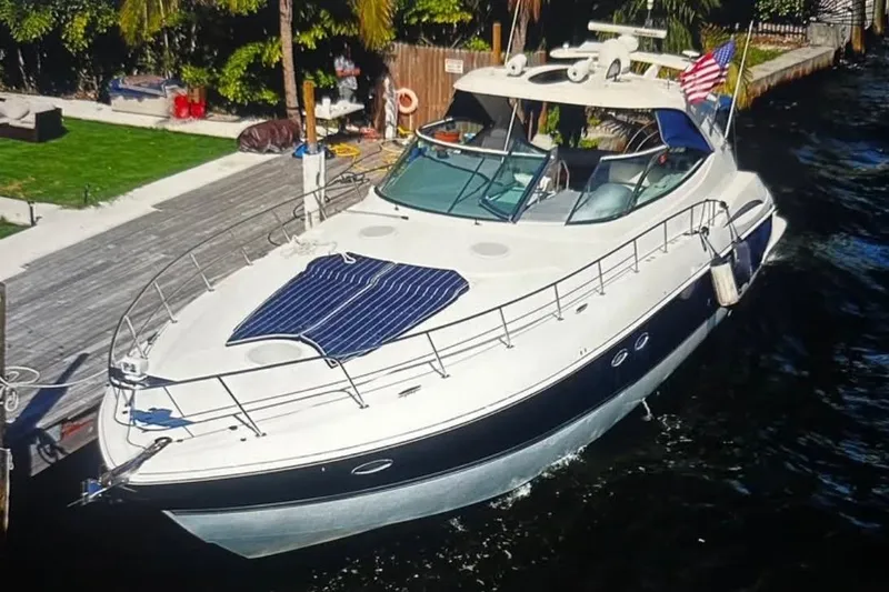 The Image of 2005 Cruisers Yachts 500 Express docked, featuring sleek design and American flag. - 0